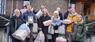 Eine Gruppe Ehrenamtlicher mit gespendeten Weihnachtsgeschenken für Kinder in der Ukraine. Unter den Helfer:innen ist auch Alfons Göris.