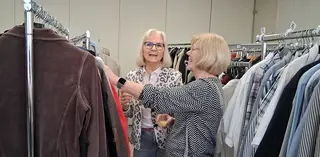 Zwei Frauen beim Gespräch inmitten der Kleidersammlung.