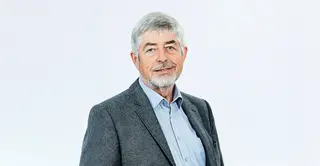 Porträt von Alfons Goris, der lächelnd in die Kamera blickt.