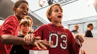 Kinder sind glücklich und haben die Hand auf einem roten Button