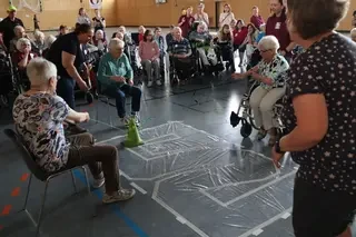 Eine Gruppe Senioren in einer Turnhalle, die gemeinsam Spiele spielen.
