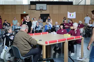 Eine Gruppe Senioren in einer Turnhalle, die gemeinsam Spiele spielen.